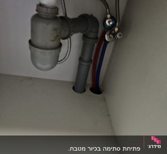 צינורות מתחת לכיור עם חיבורים ואביזרי אינסטלציה
